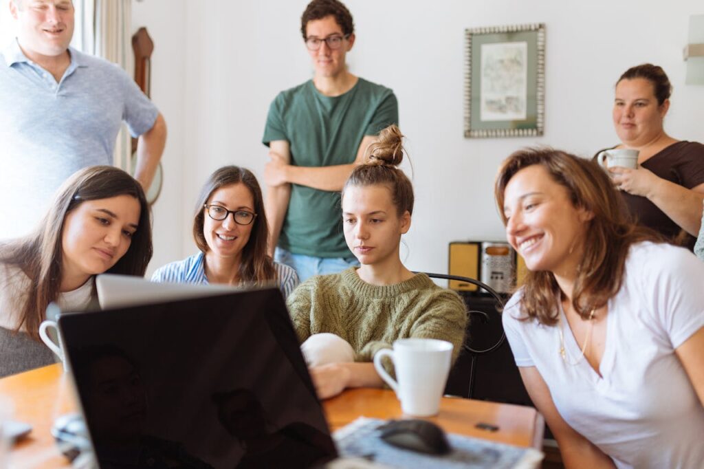 pexels-photo-1595391 A diverse group of adults at work, enjoying a casual meeting indoors with focus and smiles.
